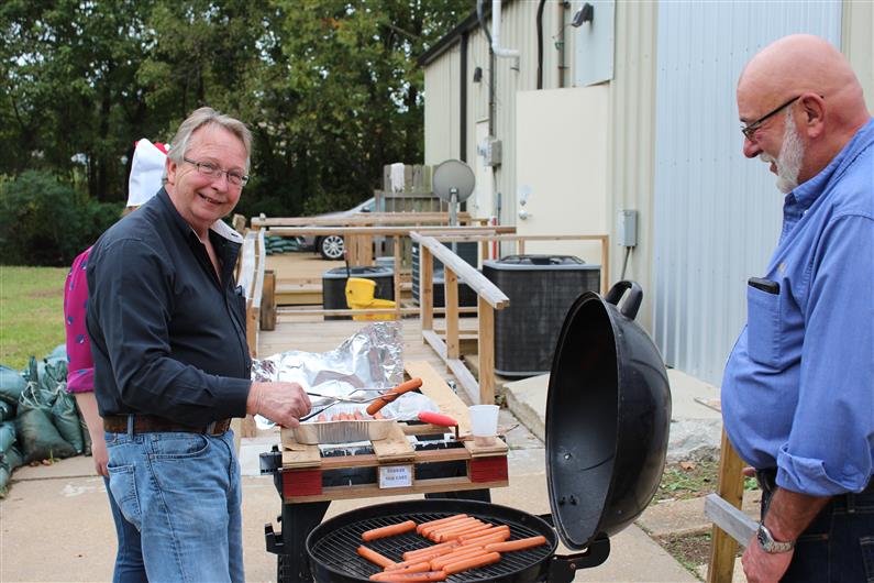 Mr. Herbert getting hot dogs off the grill